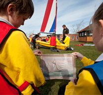 Children compare modern boat to painting of old boat