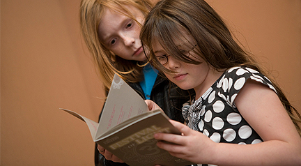 Two girls looking at a Festival of Light Brochure