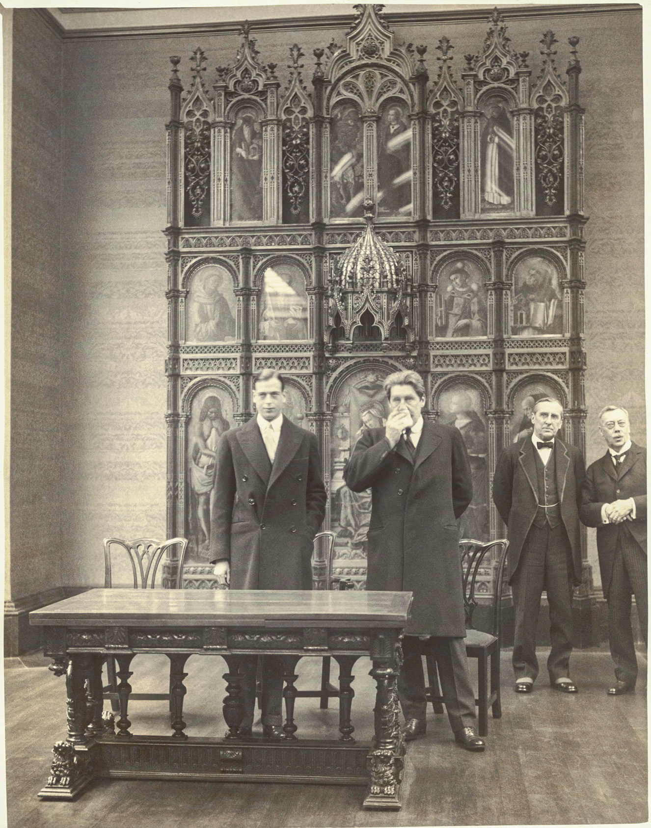 The opening of the Duveen room in 1930. Standing from right to left are A M Daniel Esq, Lord Lee, Lord Crawford and HRH Prince George. They are standing in front of the Demidoff Altarpiece by Crivelli.