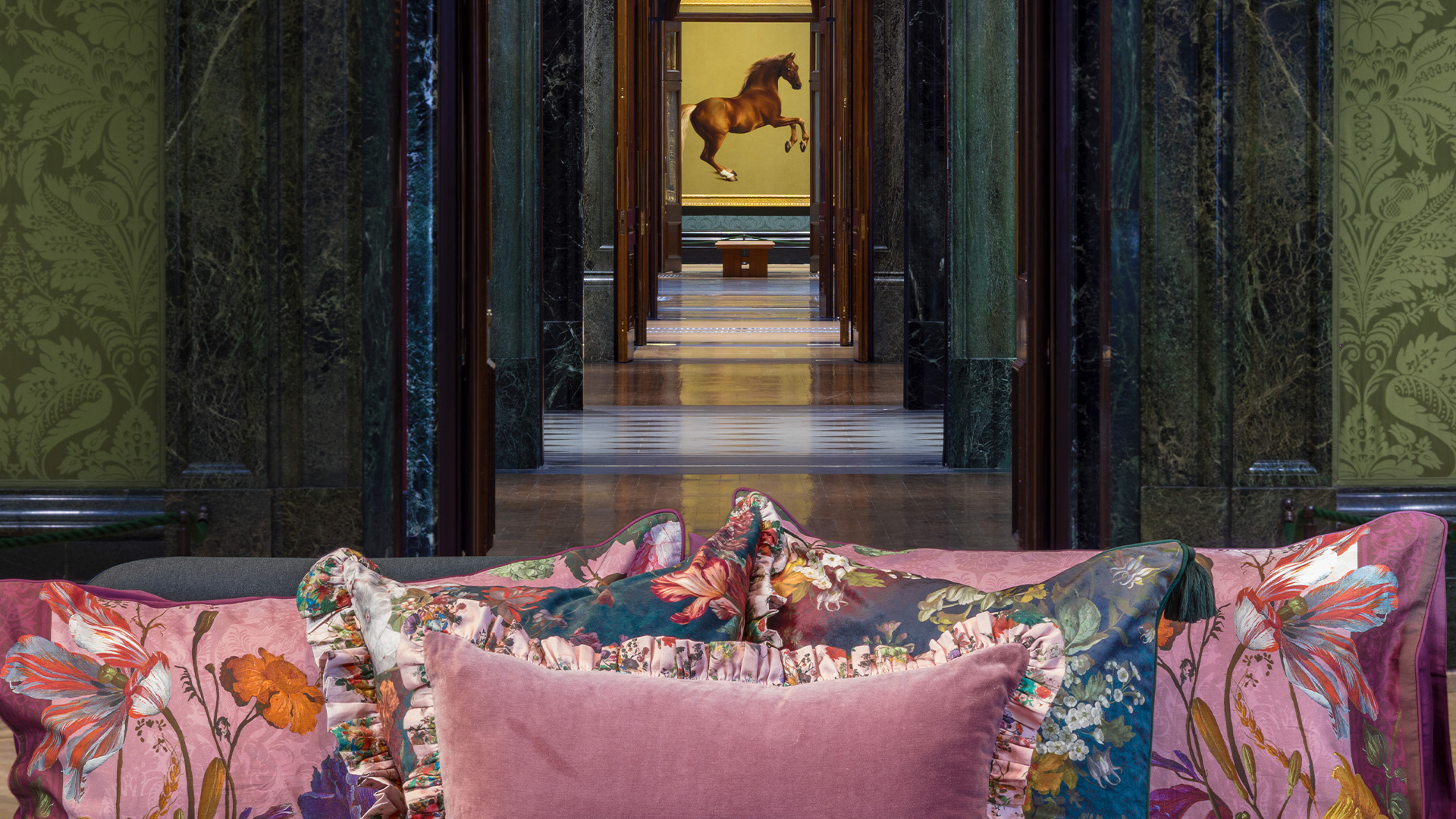 Pillows on a bed in the middle of the National Gallery. A painting is visible in the background.