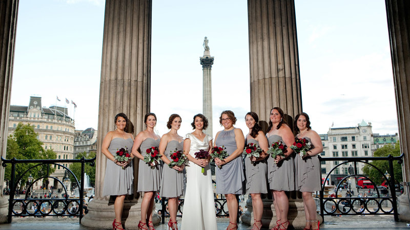 Bride and bridesmaids standing on the Portico of the National Gallery with Nelson's column in the background
