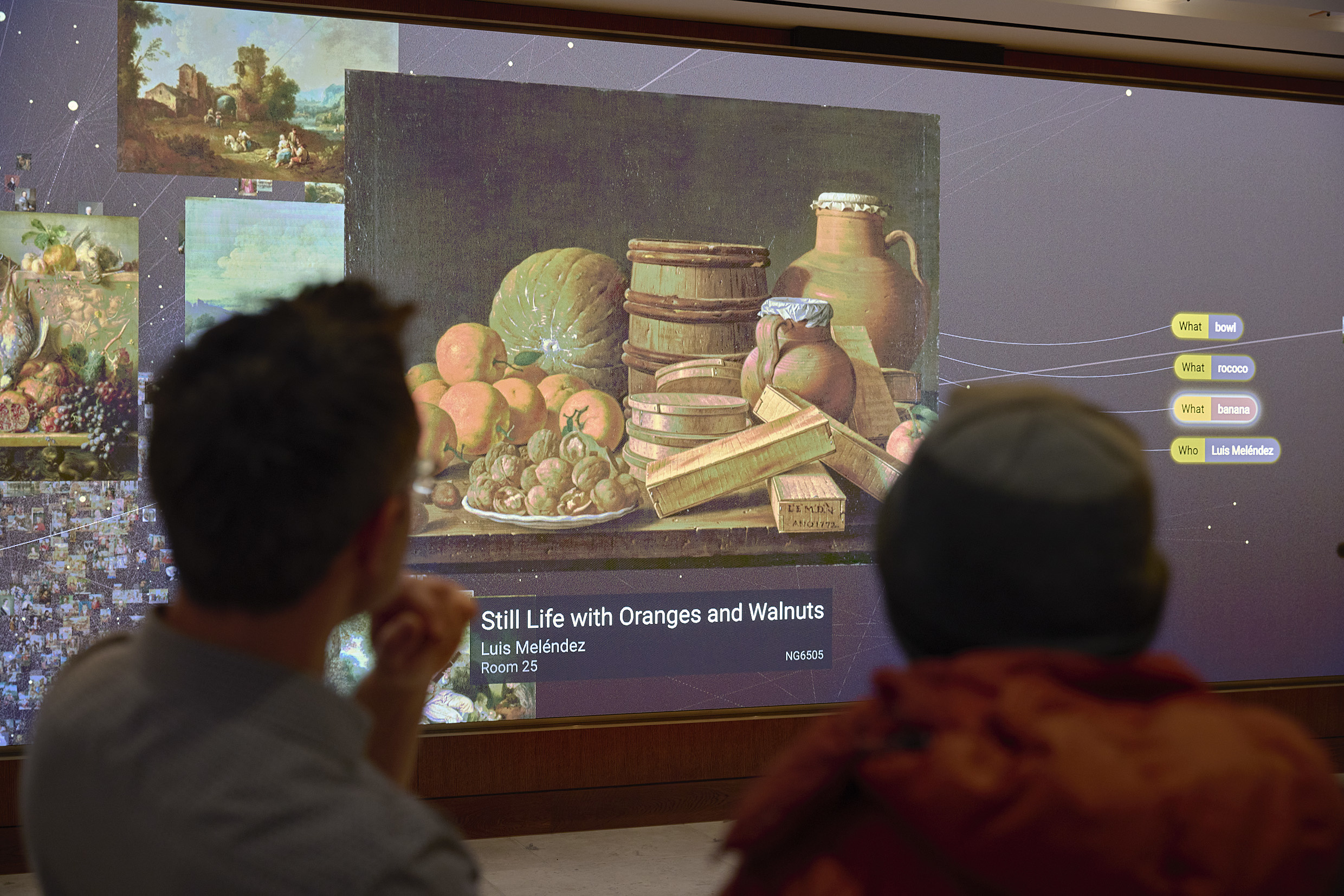 Two people look at a large screen showing 'Dreaming' by Numiko.