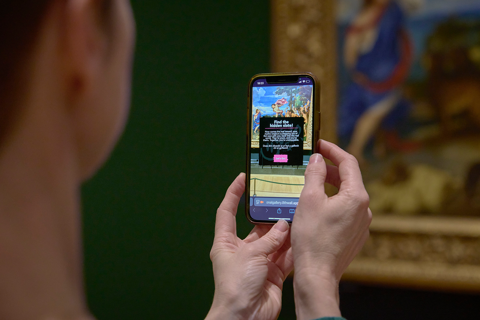 A visitor explores the National Gallery Collection using the Carreg Ateb AR experience.