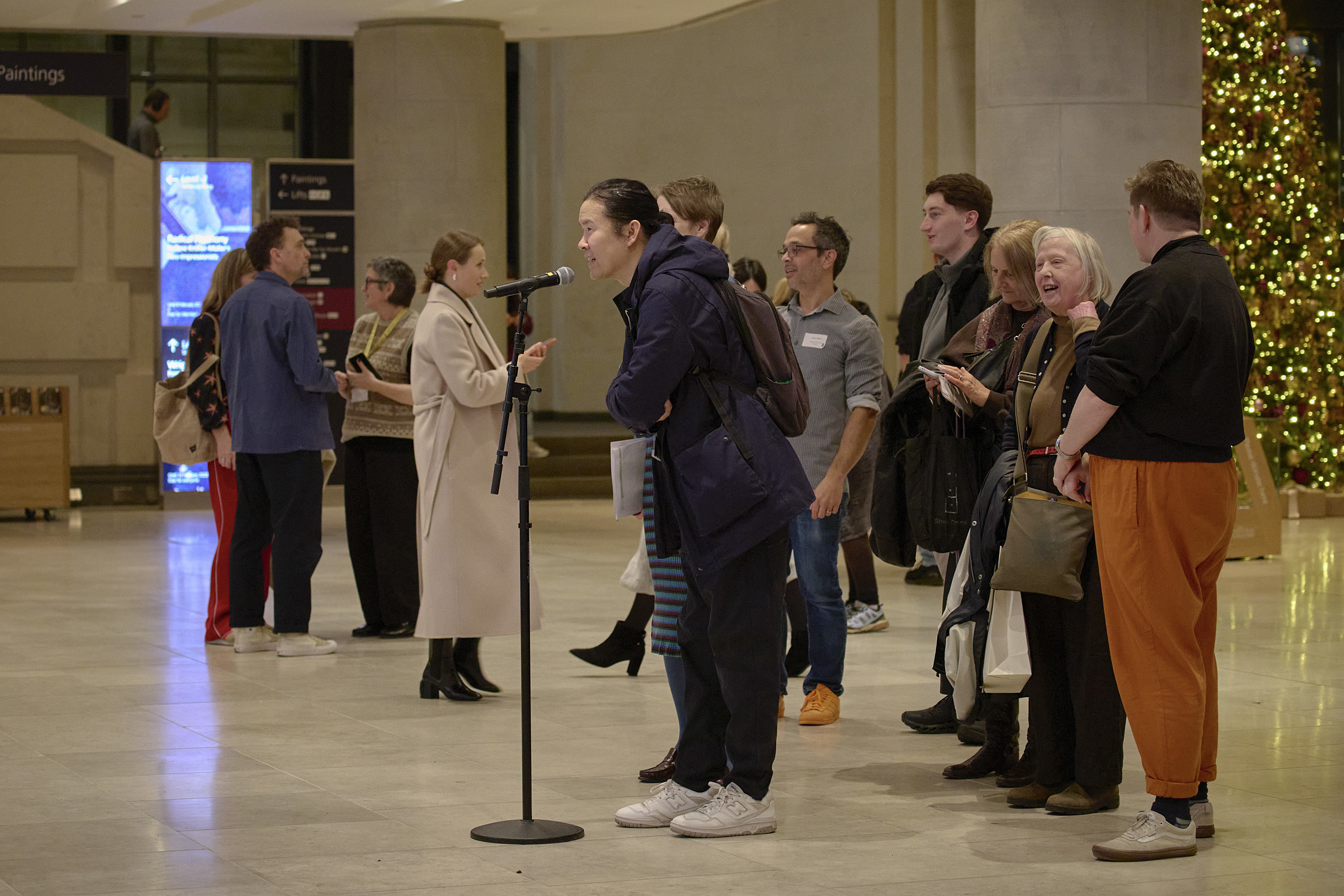 A visitor speaks into a microphone as part of digital artwork 'Dreaming' by Numiko.