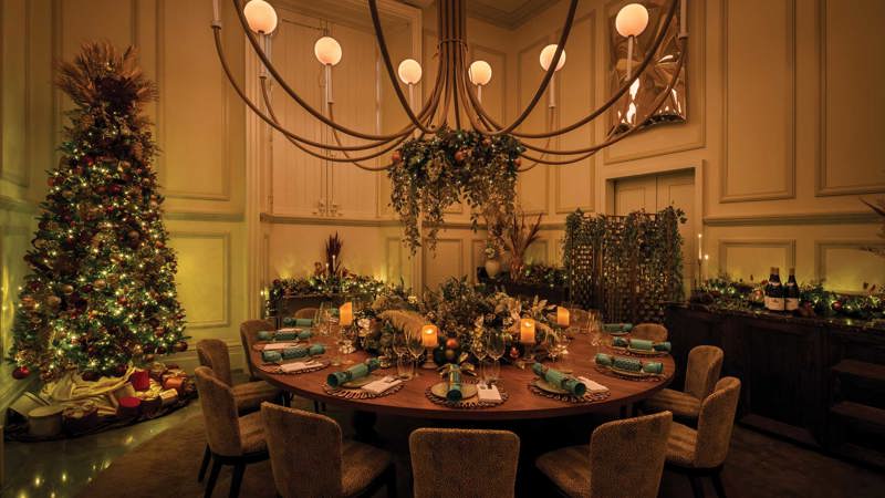 The private dining room at Ochre dressed for Christmas, with festive decorations, warm lighting and a twinkling Christmas tree