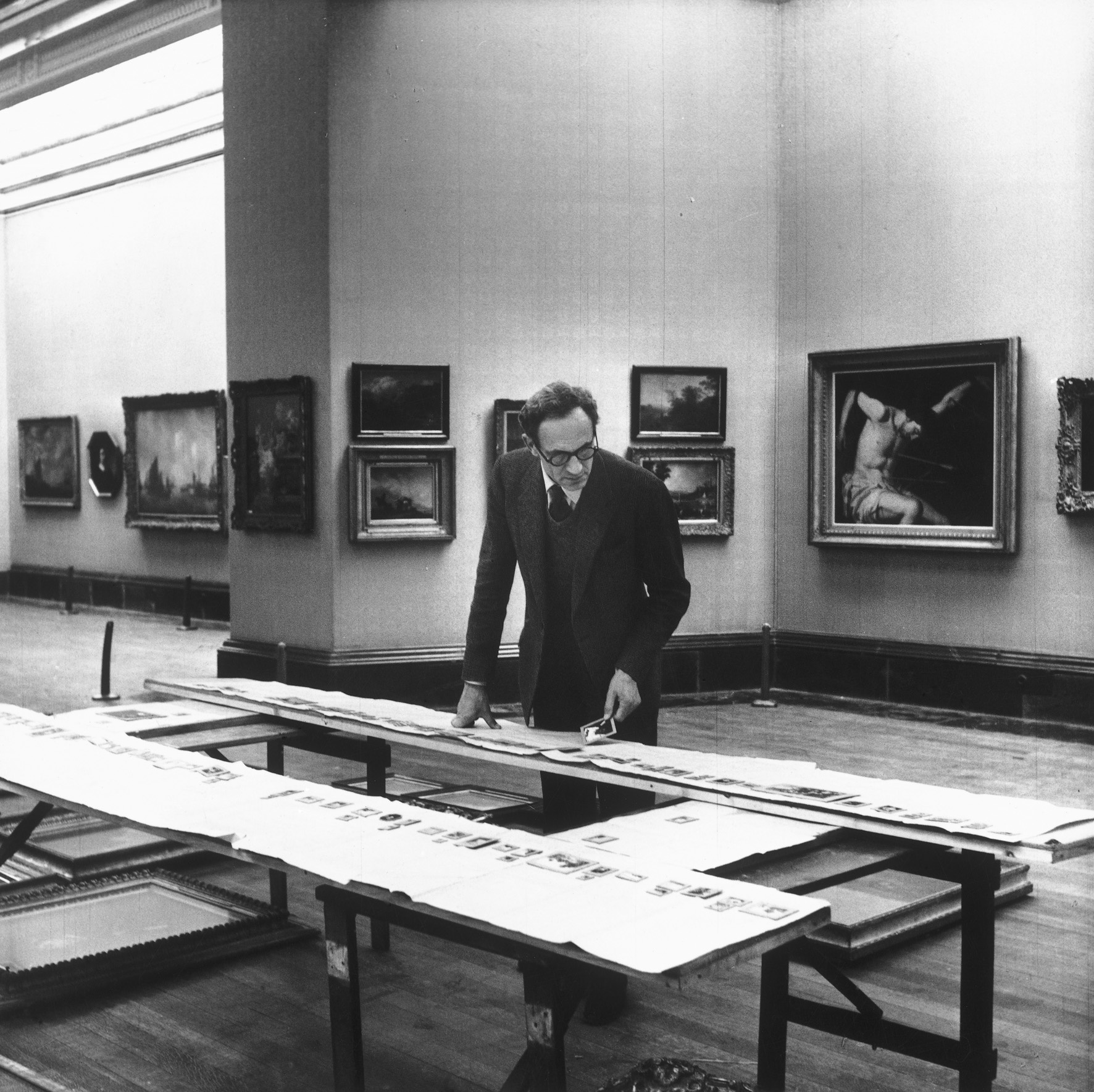 Sir Philip Hendy rehanging paintings in Duveen room, 1956.