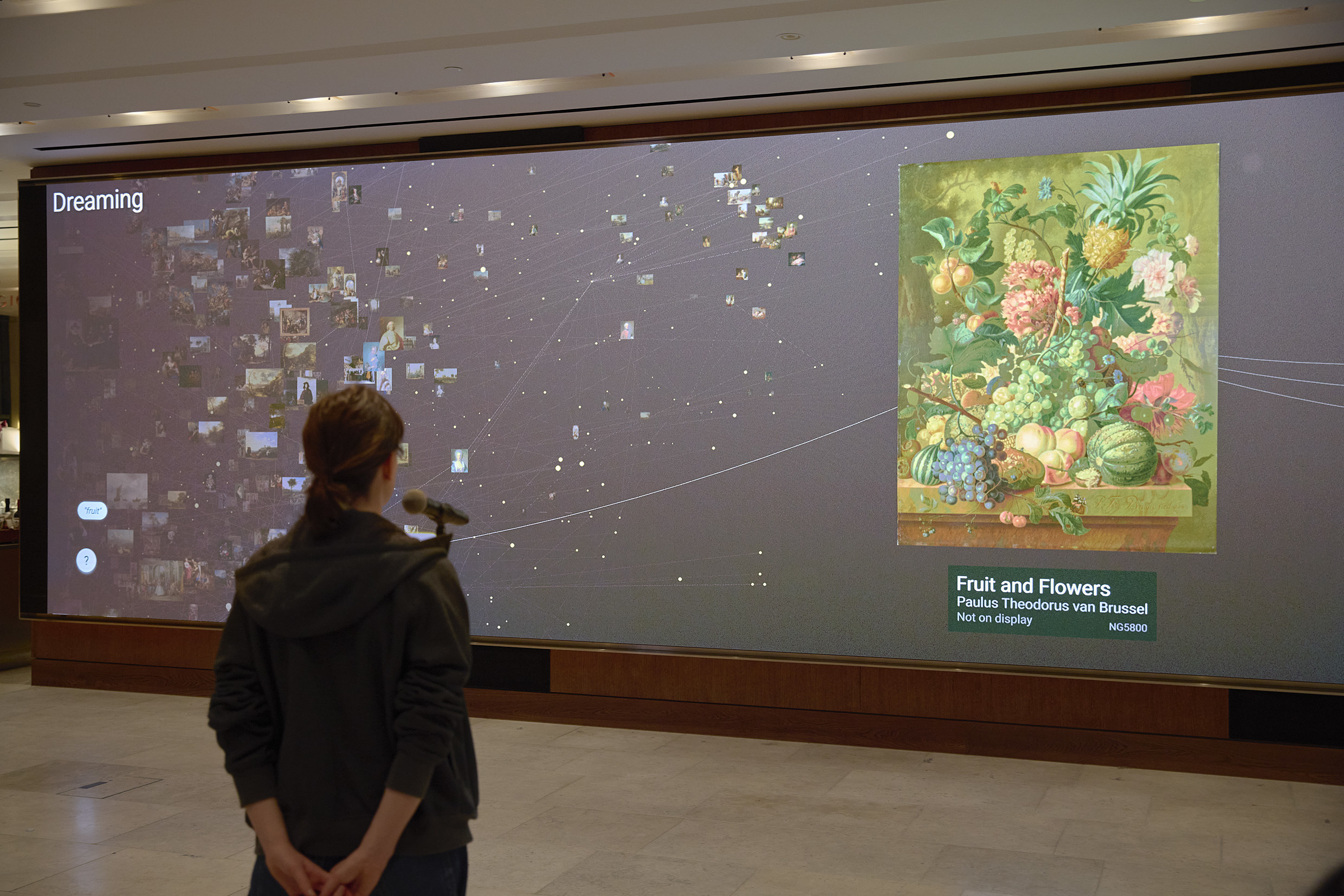 A visitor speaks into a microphone as part of digital artwork 'Dreaming' by Numiko.