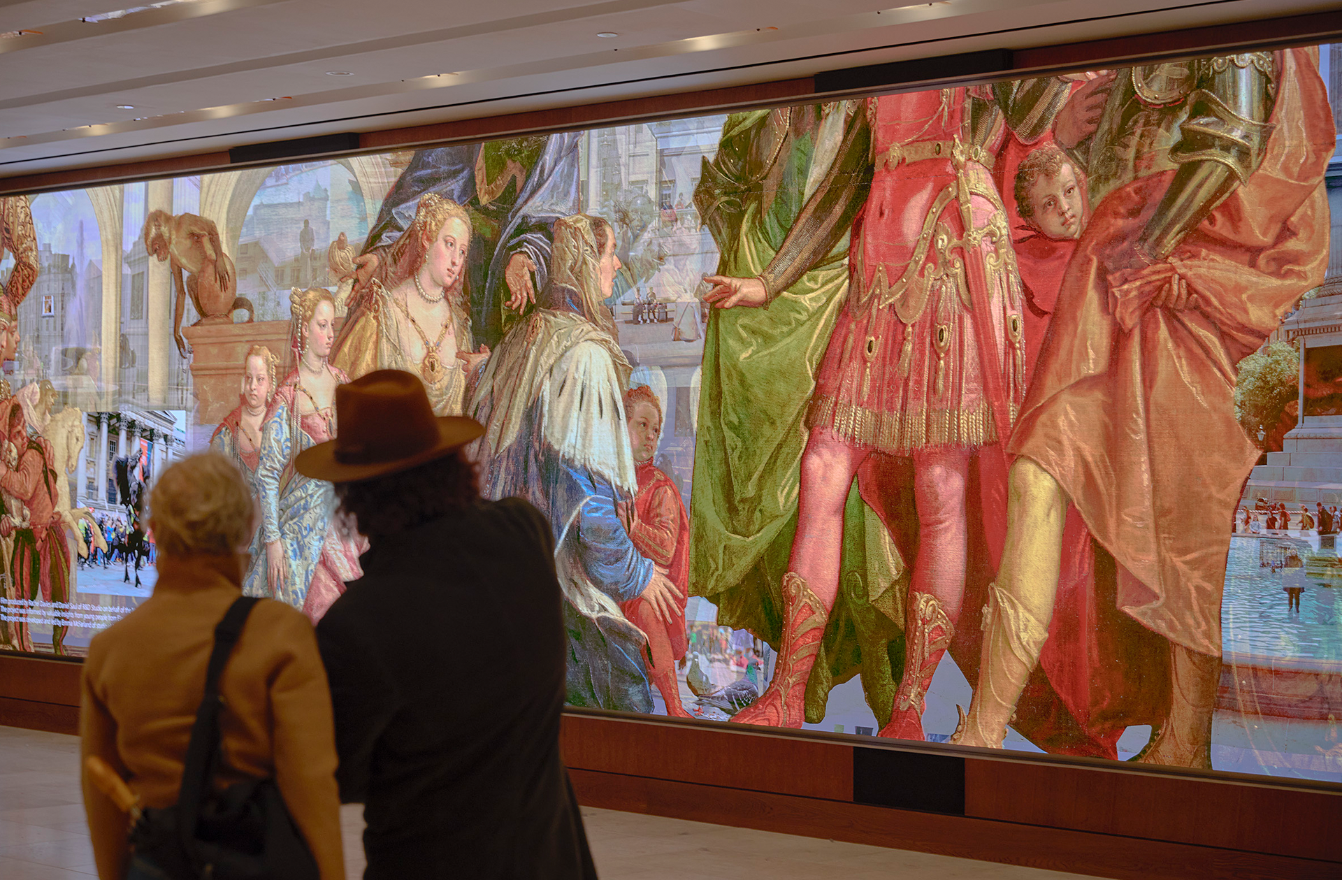 Visitors watch the Community Connector film on the Big Screen in the Sainsbury Wing in the National Gallery.
