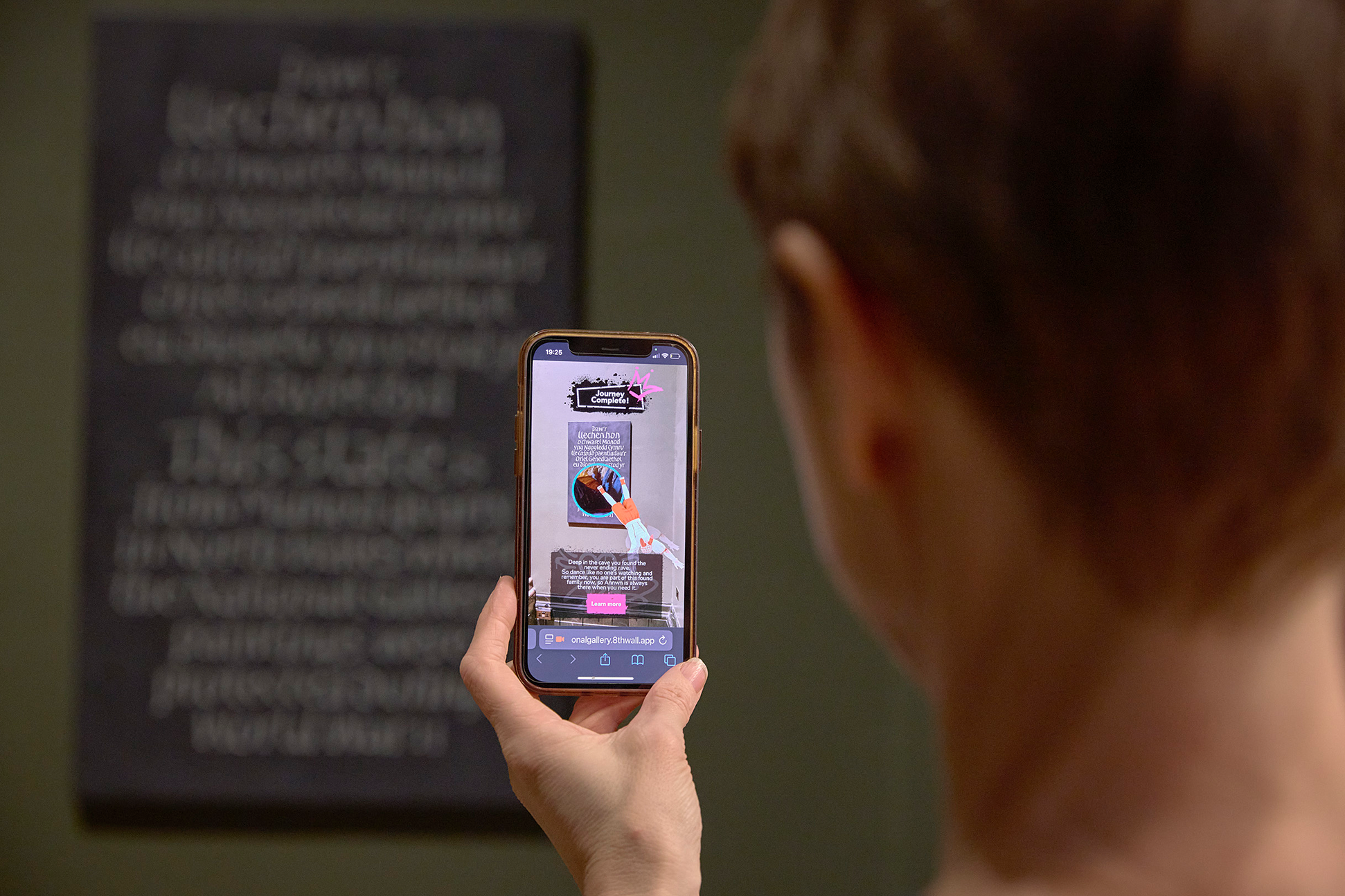 A visitor explores the National Gallery Collection using the Carreg Ateb AR experience.