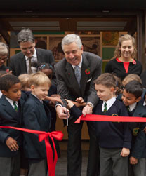 Mark Pigott cutting ribbon with primary school children outside the Pigott Education Centre